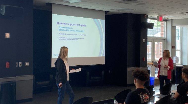 Kathie O’Callaghan, Founder & President of Hearts and Homes for Refugees (right) and Program Director, Amy Robertson (left), speak with students about the organization’s work with supporting local refugees.