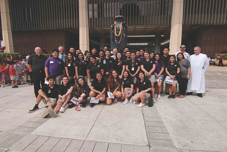 Students and staff members from Damien Memorial
pose for a picture with St. Damien’s statue before
praying for the homeless at the state capital on his
feast day, May 10. Pictured with the group are the
Bishop of Honolulu, Larry Silva (far left) and Provincial
of The Congregation of the Sacred Hearts of Jesus
and Mary, Herman Gomes (far right).
