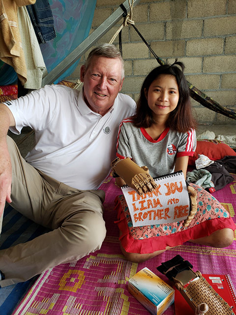Brother Rice Chicago alumnus and Chairman Emeritus of Love Without Boundaries, Paul Duggan poses with a recipient of one of Brother Rice’s “Helping Hands” in Cambodia.